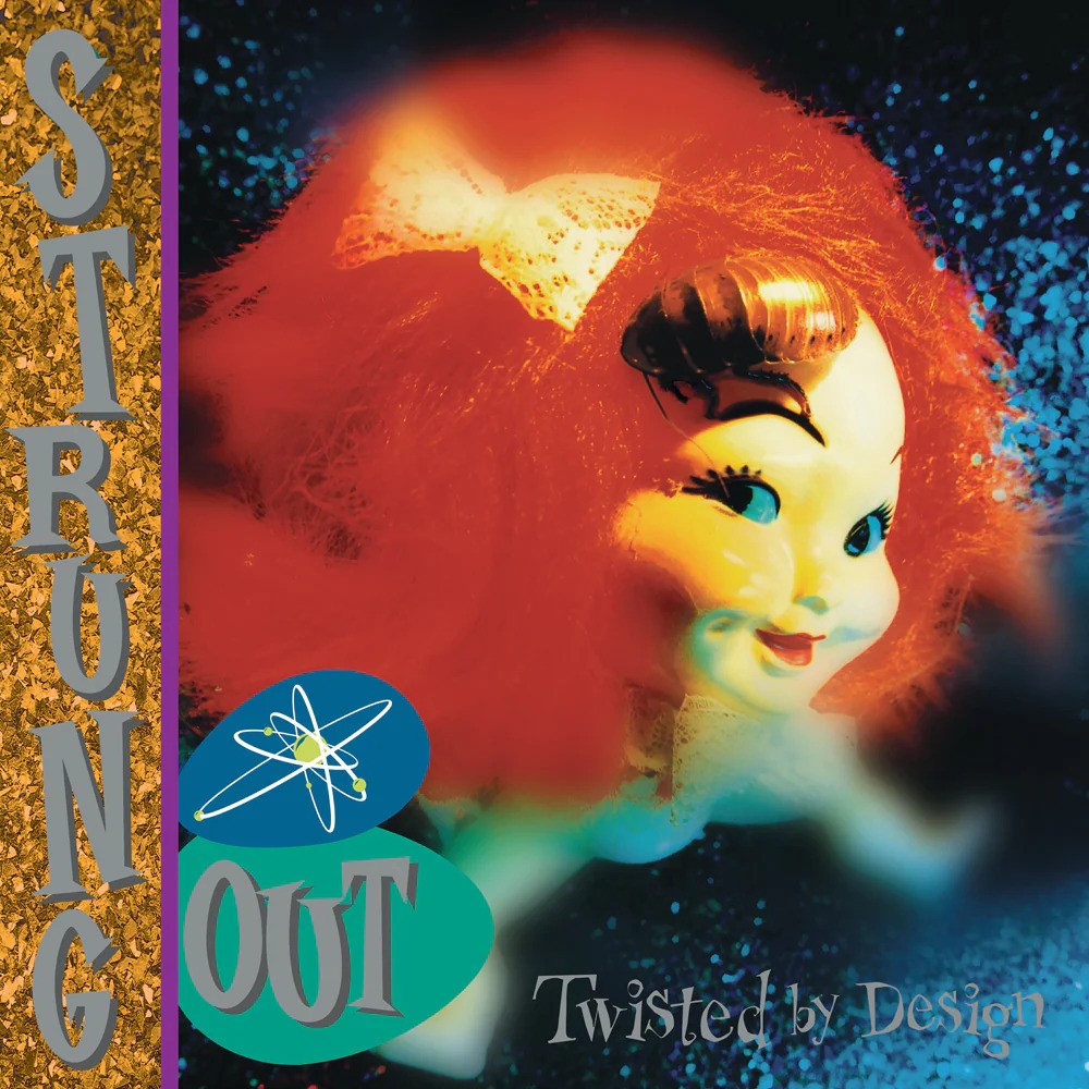 Strung Out’s Twisted By Design album cover shows a red-haired dolls head with a white bow on a sparkling, blurry background. The brand name, Strung Out, and the album title are displayed in stylized fonts on classic black vinyl.