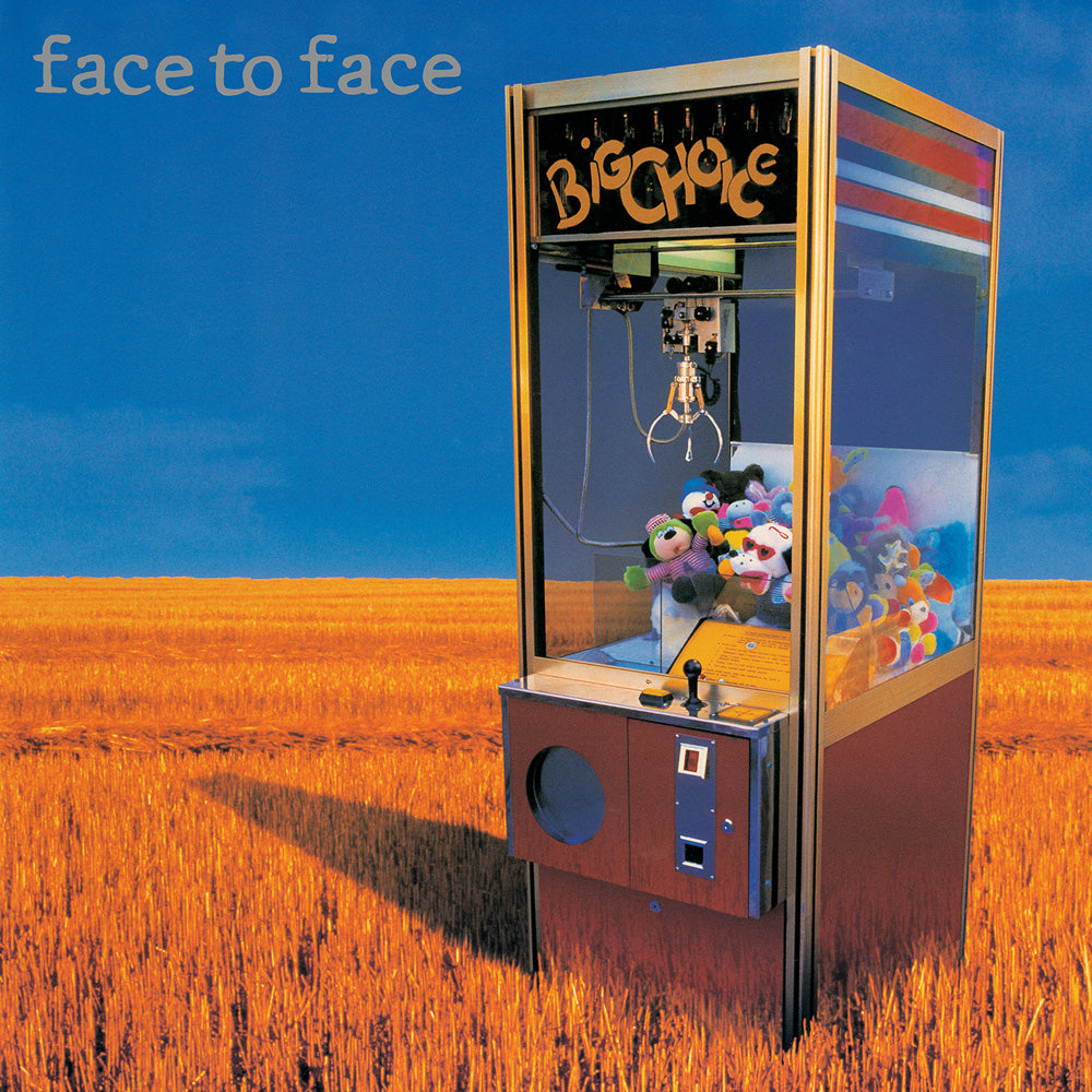 A claw machine packed with plush toys and a Black Vinyl LP stands in a golden wheat field under a blue sky. face to face appears top left, and the Face To Face-branded BIG CHOICE logo is written on the machine.