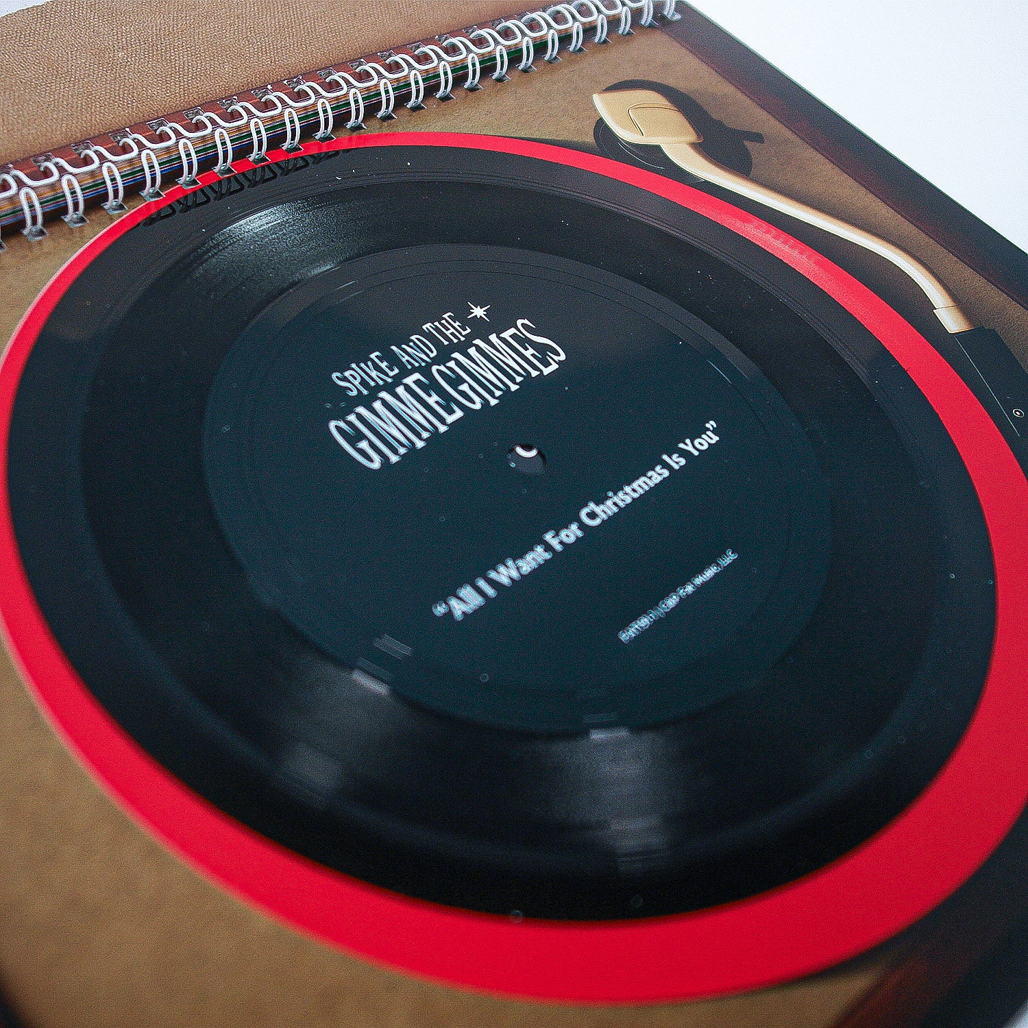  Flexi vinyl by Spike and The Gimme Gimmes titled “All I Want For Christmas Is You” spins on a tan turntable, featuring a visible tonearm and the Fat Wreck Chords logo in the corner.