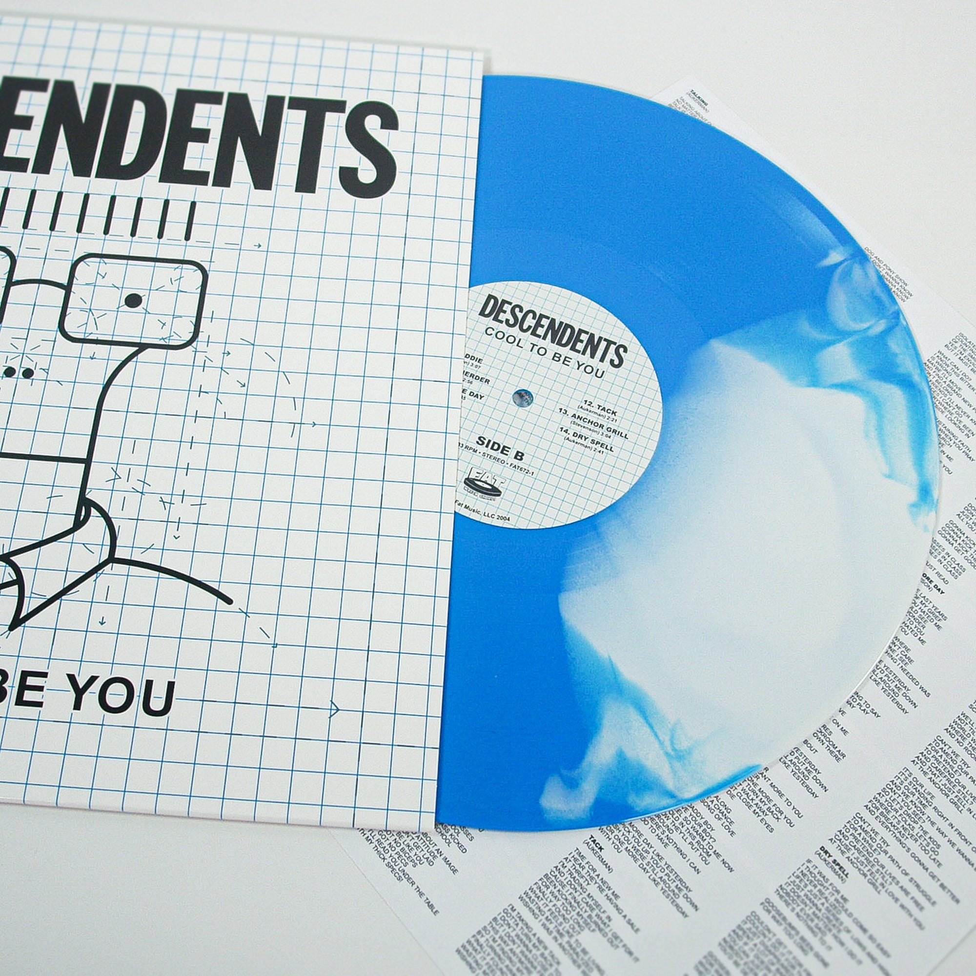 A blue and white marbled Descendents Blue & White Butterfly LP partially in its sleeve, featuring the Cool to Be You album cover, sits next to a printed lyrics insert.